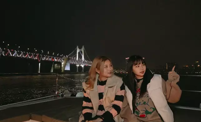 兩位女生晚上乘搭觀光船遊覽釜山夜景。 