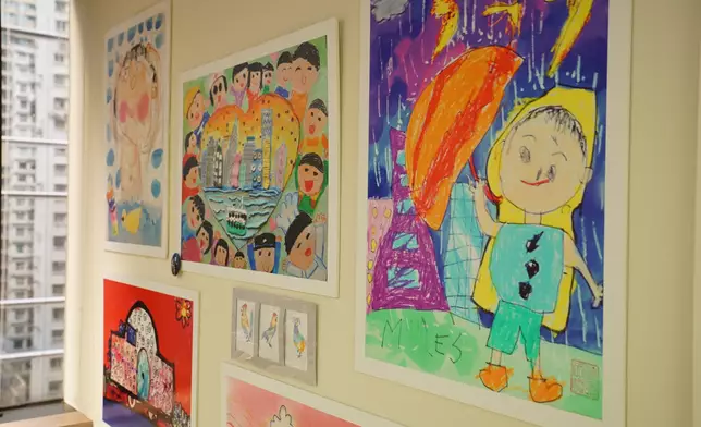 圖片說明：辦公室牆壁上是兒童的畫作，最右一幅是梁太孫兒Miles的作品。