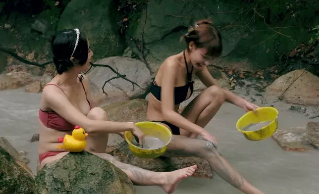 佢哋坐喺泉邊玩泥漿。