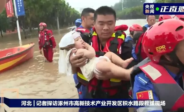 救援人員在受災地區轉移民眾。（央視新聞圖片）