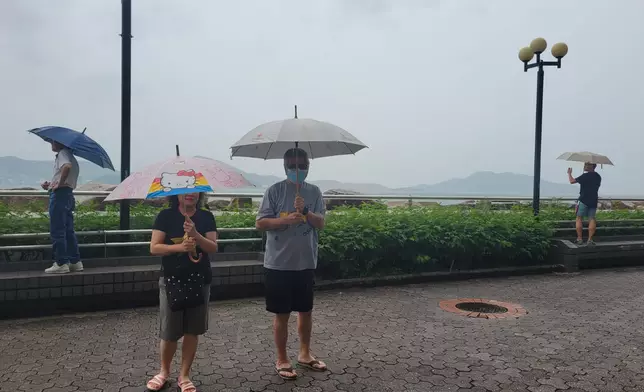 居民鍾先生夫婦也在海旁觀察風浪情況。(巴士的報記者攝)