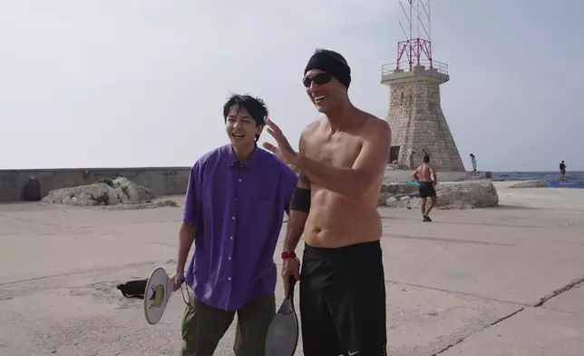 Arthur走到海邊玩沙灘網球。