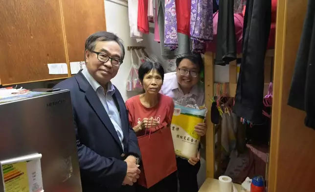 全國政協委員兼立法會議員盧偉國（左一）為居民送上福米。