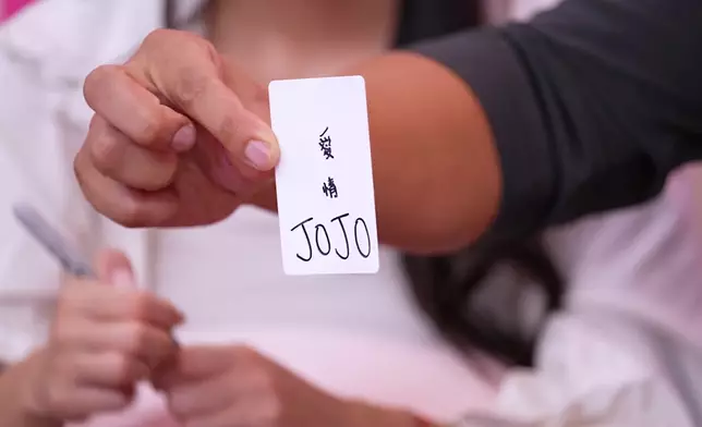 Jojo在卡牌上寫上簽名。