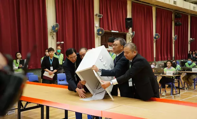 陸啟康、曾國衛、石丹理、文本立巡視票站並及倒出票箱中的選票。巴士的報記者