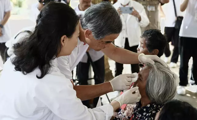 梁振英為接受全球第1萬宗手術的病人揭開紗布。(基金會圖片)