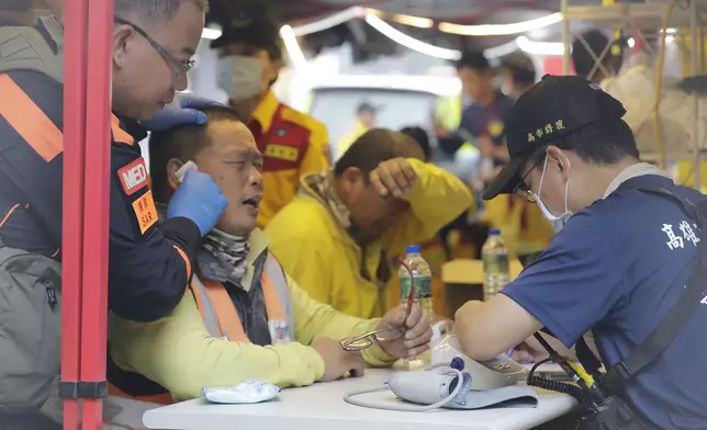 兩名在地震發生時被困太魯閣國家公園的工人，獲救後正在接受身體檢查。(AP圖片)