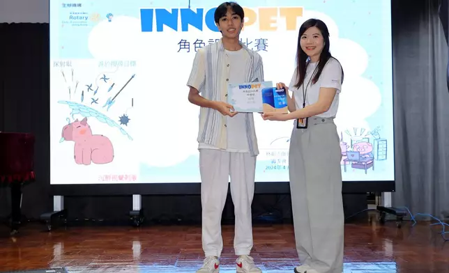 大埔衛星同行扶輪社剛卸任主席周寶心女士（右）頒獎予INNOPET 角色設計比賽中學組冠軍賴天賜（左）。