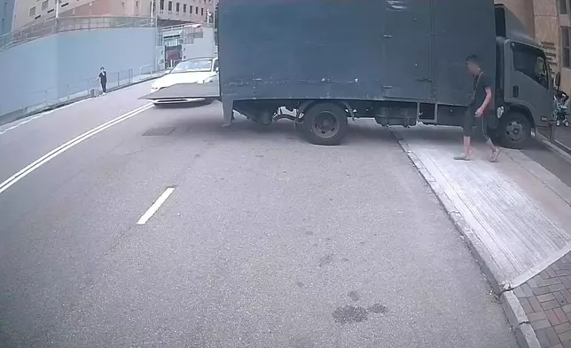一架貨車在路中心打開尾板，後隨白色私家車駛至。(Sing Yiu@車cam L（香港群組）短片截圖）