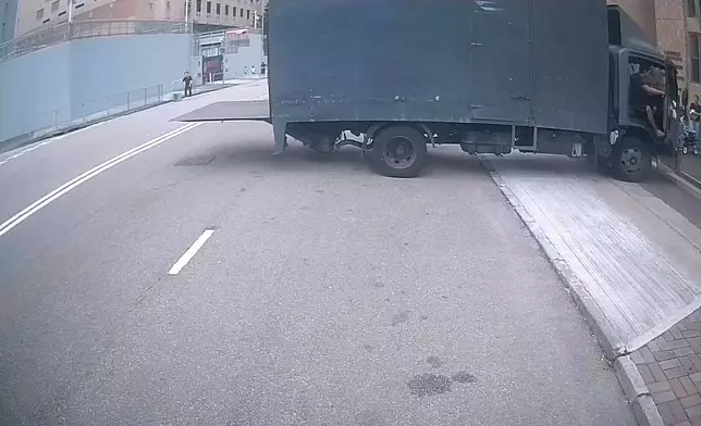 一架貨車在路中心打開尾板。(Sing Yiu@車cam L（香港群組）短片截圖）