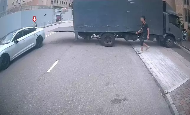 一架貨車在路中心打開尾板，後隨白色私家車駛至，側鏡被尾板撞碎飛脫(紅箭嘴所示)。(Sing Yiu@車cam L（香港群組）短片截圖）