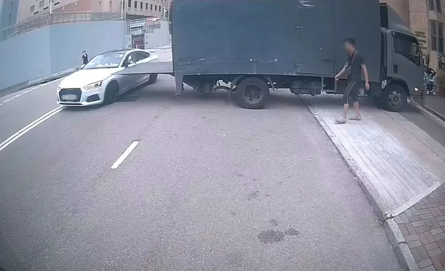 一架貨車在路中心打開尾板，後隨白色私家車駛至，側鏡擦過尾板。(Sing Yiu@車cam L（香港群組）短片截圖）