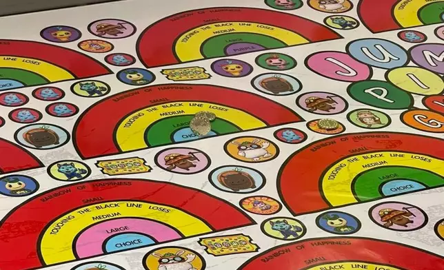 有女童於冒險樂園玩掟彩虹，代幣以垂直方式置於藍色圈圈範圍內。（FB「美國冒險樂園關注組」圖片）