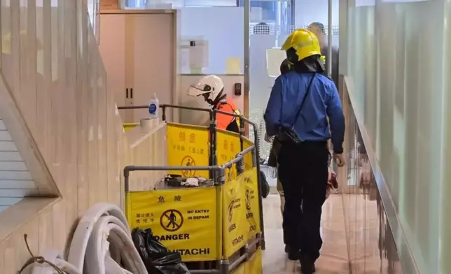 一名18歲工人跌落大廈扶手電梯槽，消防正在設法救出事主。有線新聞圖片