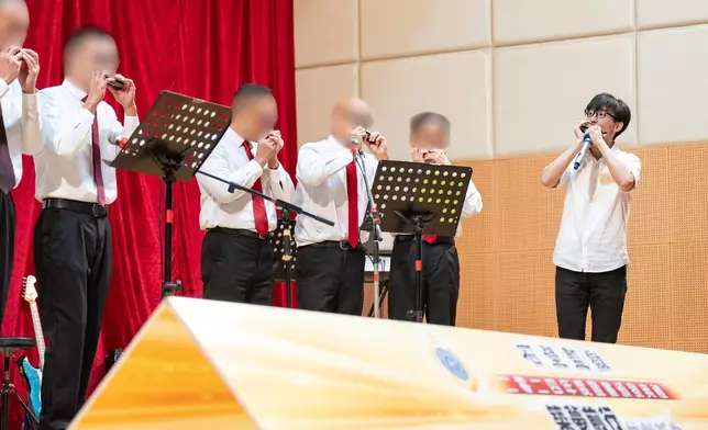 義工導師口琴演奏家梁栢渝（右一）夥拍在囚人士以口琴演奏樂曲。 政府新聞處圖片