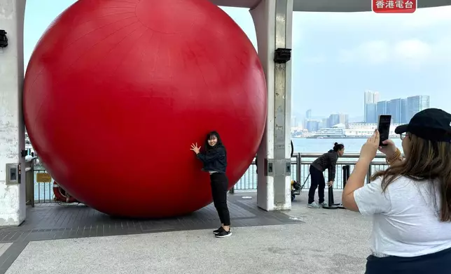 有人擺出不同姿勢與「紅球」合照。