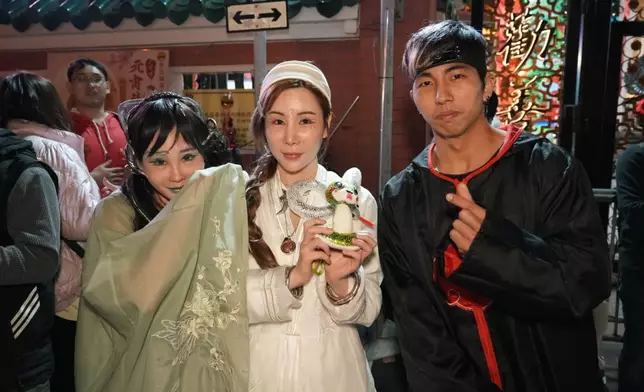 艾美琦（中）、李子彤（左）爭上黃大仙祠頭炷香。巴士的報記者攝