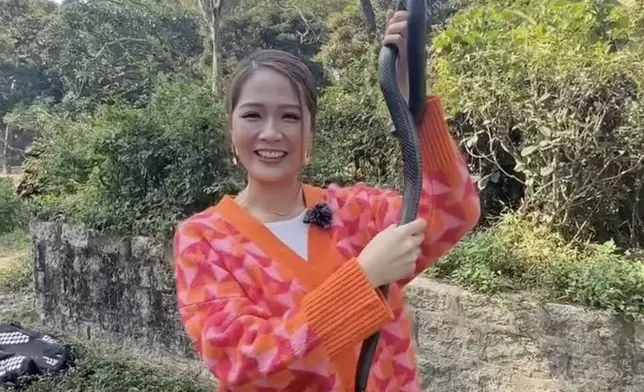 任由黑蛇纏上手臂。