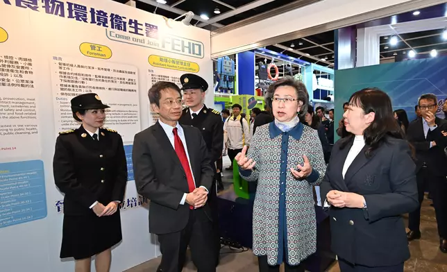 楊何蓓茵（右二）參觀食物環境衞生署的攤位。旁為公務員事務局常任秘書長梁卓文（左二）。 政府新聞處圖片
