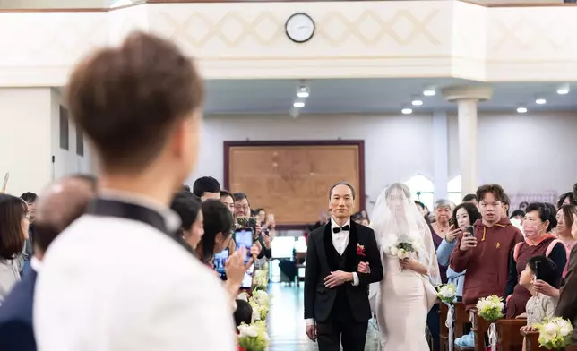 換上低胸貼身婚紗的貓仔由黎爸爸拖住現身。