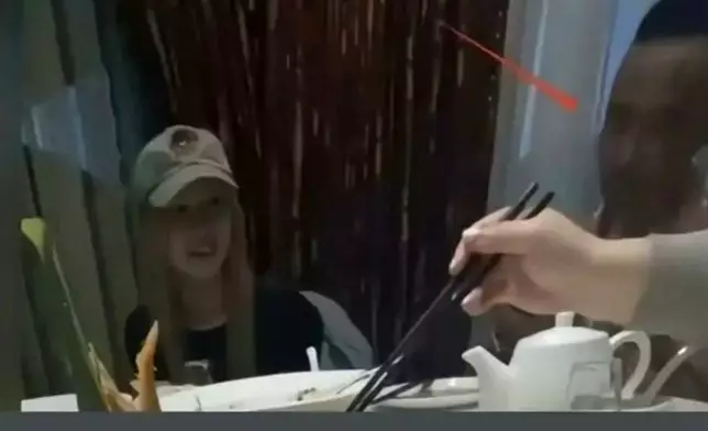 被指是葉延偉的光頭男士低頭玩手機。
