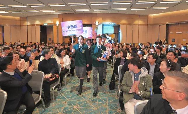 來自十八區的學生代表手持「香港參與國際評估計劃─吉祥物設計比賽」的冠軍作品進場。 政府新聞處圖片