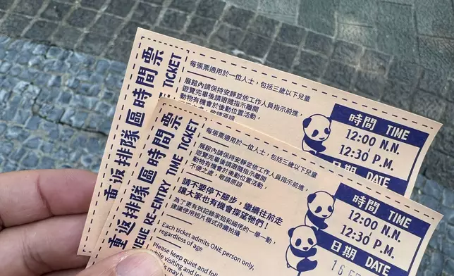 園方因應現場排隊人數分流，派發重返排隊區時間票，參觀者需跟據票上時間再排隊入館。(巴士的報記者攝)