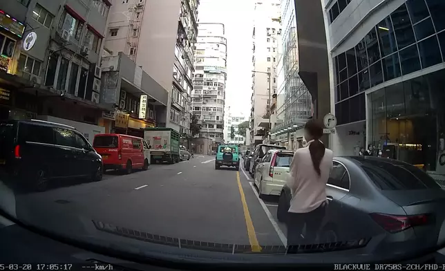 尖沙咀女子抱狗敲車窗求助影片截圖。Eric Chu@車CAM L
