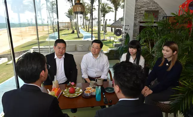 李家超（後排左二）與在海南創業及工作的香港青年交流。 政府新聞處圖片