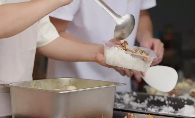 將飯盒送到老人家手中。