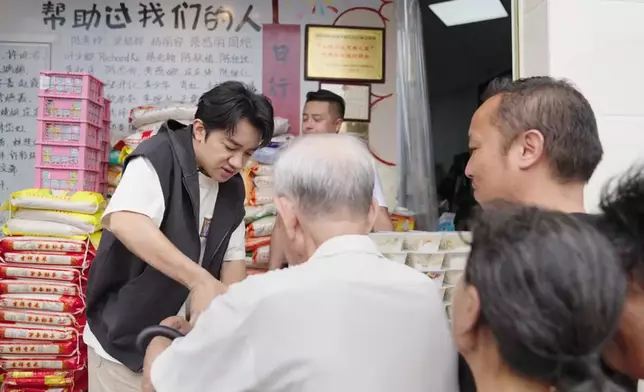 將飯盒送到老人家手中。