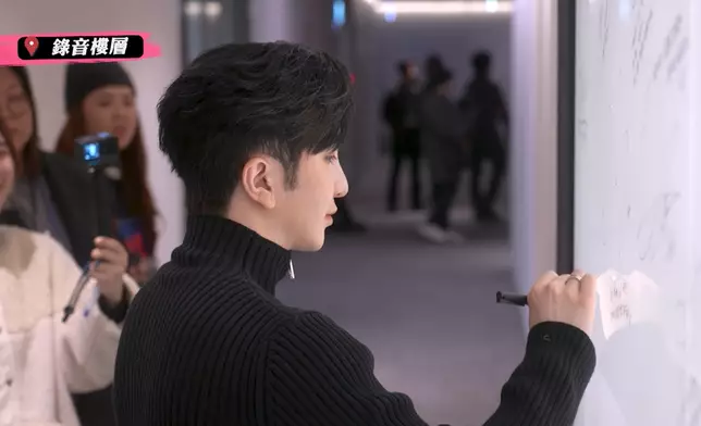 Anson Lo在SM 藝人簽名牆上簽名。