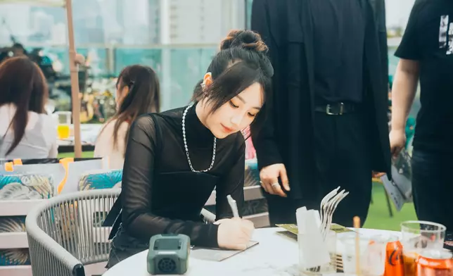 Windy逐一為粉絲在相冊上簽名。