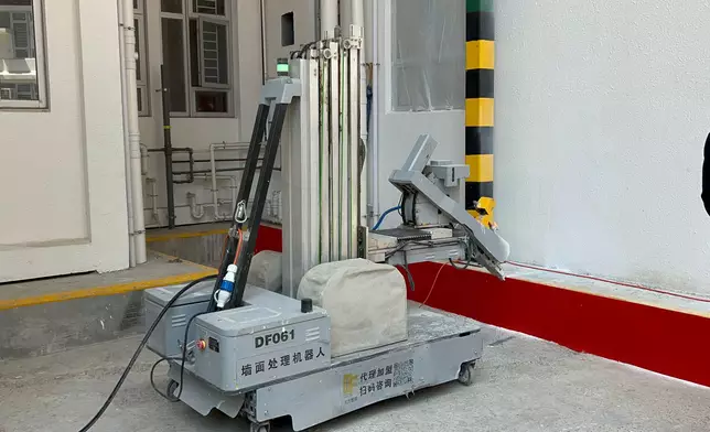 6米牆面處理機械人集抹灰、混凝土牆面打磨、噴塗/抹刮膩子、膩子牆面打磨、乳膠漆噴塗功能於一體，最高施工高度可達6米，實現自動行駛和施工，並根據場景資料庫資訊以自動判斷障礙物和避障。巴士的報記者攝