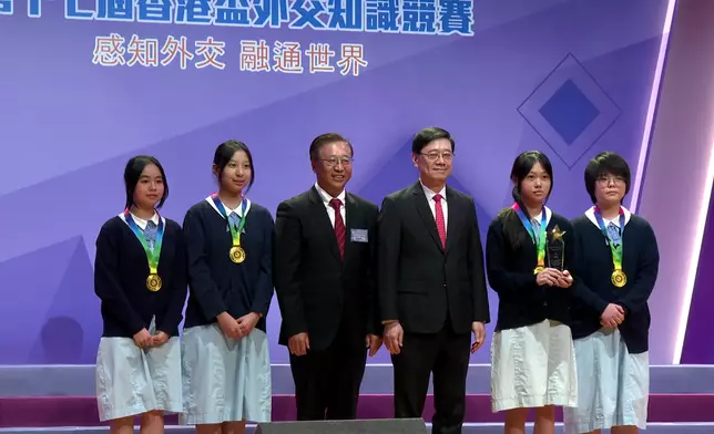 李家超（右三）和外交部駐香港特別行政區特派員公署特派員崔建春（左三）頒獎予冠軍明愛屯門馬登基金中學。巴士的報記者攝