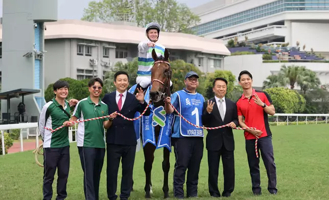 「遨遊氣泡」的練馬師姚本輝（右二）及馬房團隊賽後祝捷。香港賽馬會圖片