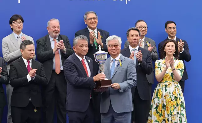 馬會董事楊紹信博士（右）在頒獎禮上將獎盃頒予「遨遊氣泡」的馬主日月輝煌賽馬團體代表程志輝。香港賽馬會圖片