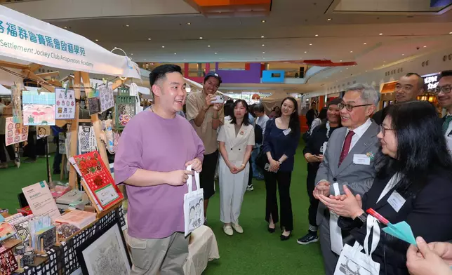 馬會董事胡家驃（右二）以及其他嘉賓參觀共融市集攤位，與殘疾人士交流。