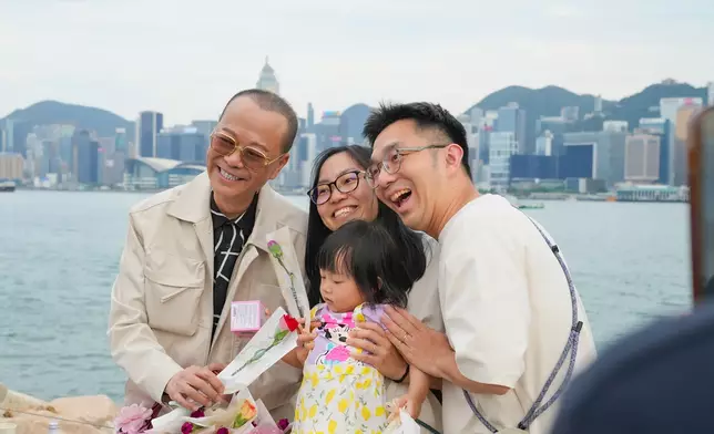 藝人歐陽震華送上母親節花束與市民一家開心合照。