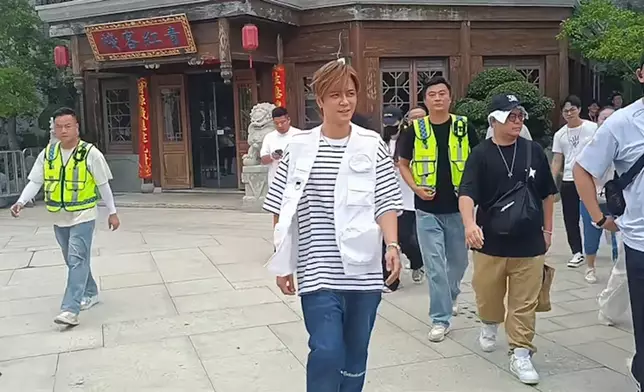 被大批工作人員團團圍住