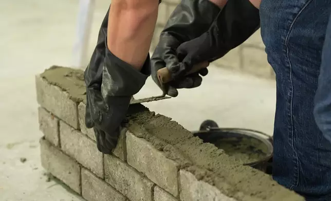 師傅「手把手」教砌磚。