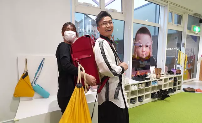 搞笑地試了超大的小朋友書包，特意扮重嚇到女職員。