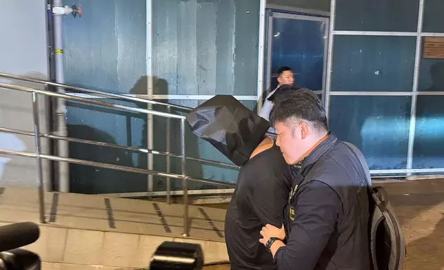 疑犯被黑布蒙頭。