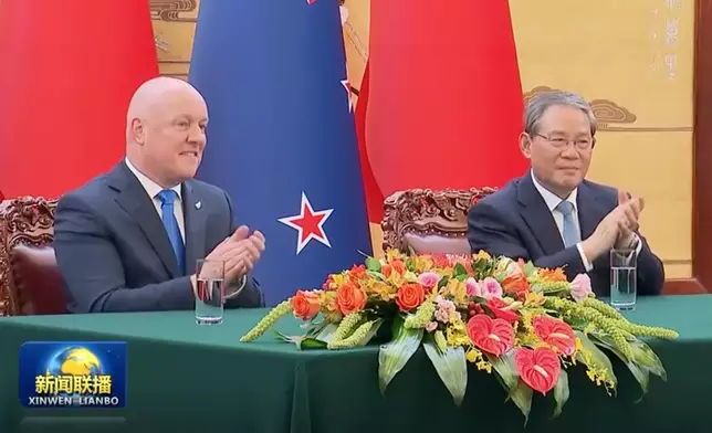 李強（右）和拉克森（左）見證兩國簽署協議。央視截圖