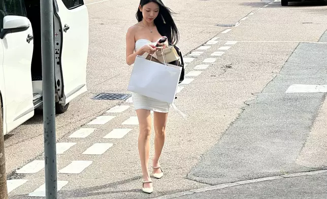 身穿白色低胸緊身連身裙。（本網記者攝）