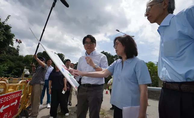 發展局局長甯漢豪（中）在沙頭角公路聽取水務署署長黃恩諾（左）介紹食水供水網絡。 政府新聞處圖片