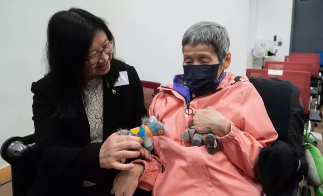 馬會慈善事務部主管（豐盛耆年及長者服務、健康社區）陳載英（左）與「賽馬會安寧頌：融和篇」計劃的服務使用者（右）合照。