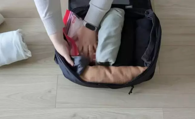 達人將T恤、內衣褲、襪子各捲成一組。影片截圖