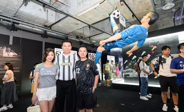 球迷在2.38米倒掛雕像留影。