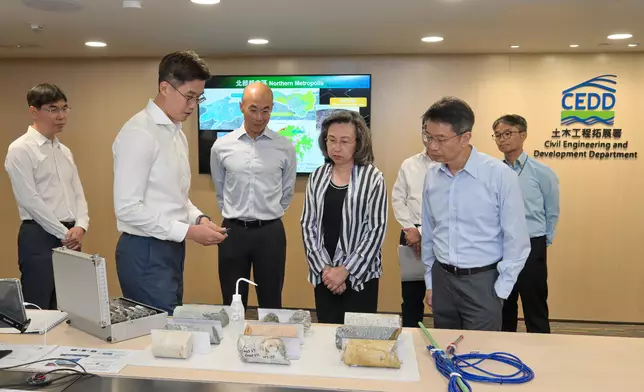 部門人員向楊何蓓茵（前排右二）講解土力工程處在新界西北部啓動的土地勘測研究，提速提效協助推動北部都會區的發展。旁為公務員事務局常任秘書長梁卓文（前排右一）及土拓署署長方學誠（前排中）。政府新聞處圖片